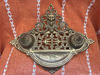 Front view showing ornate brass double inkwell with lids and tray