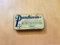 Front view of yellow Panflavin Pastillen tin showing branding and text