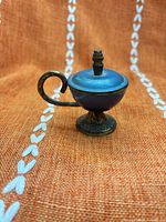 Front view of blue enamel brass miniature lidded urn with curved handle and pedestal base