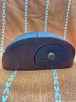 front view of curved wooden puzzle box with knob