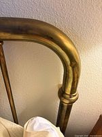 Close view of brass headboard corner showing material and finish