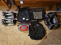 Two Reebok SpeedPac dumbbell sets with six assorted bags arranged on carpet