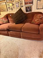 Front view of reddish-brown microfiber sofa with three throw pillows