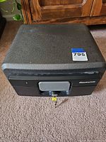 Closed SentrySafe lockbox showing exterior and key inserted