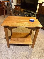 Front angle view showing full table, legs, lower shelf, blue tape on top