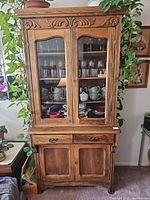 Full front view of oak hutch showing glass doors, drawers, lower doors