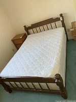 Full view of double bed showing headboard, footboard, rails, mattress, cover