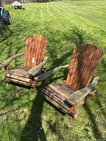 Both wood Adirondack chairs folded open on grass