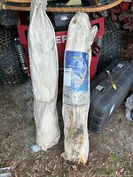 Two swing hammocks inside off-white canvas bags, one with blue label, dirt/moisture staining at bottoms
