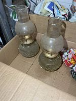 Both glass oil lamps with chimneys inside box
