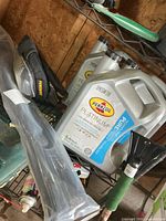 Shelf with Pennzoil oil jugs, cable ties bundle, knee pads, snow brush and other items