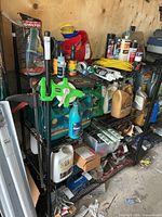 Full view of black metal wire shelving rack loaded with various garage supplies