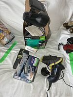 All items grouped: Noma solar spotlight box, solar dock lights box, stud sensor, cordless driver with charger