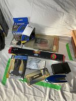 Overall view of assorted packaged and loose tools on sheet