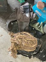 View of both pairs of waders, fishing net, and bag on floor