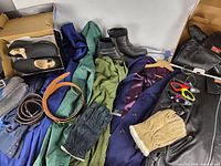 Overview of clothing, footwear, belts, gloves on table