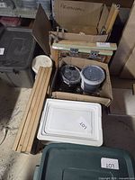 Overview of lot showing box with hinge clamps, two ink pails, wood slats and plastic lid