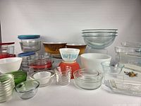 Overall view of entire glassware lot showing patterned bowls, clear bowls, milk glass and ribbed containers