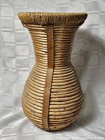 Side view of hourglass-shaped rattan basket with ruler for scale