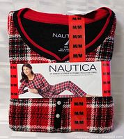 Front of factory-folded Nautica pajama set showing plaid fabric, model image, size M labels