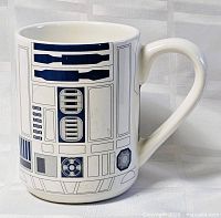 Front view of white ceramic mug showing R2-D2 graphics