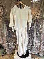 Front view of full-length cream jumper on hanger