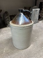 Full view of 5-gallon stoneware jug showing cream body and brown shoulder with handle