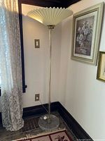 Full view of lamp beside wall showing column, base, and shade