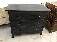 Front view showing three drawers and knobs