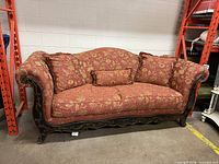 Front view of Broyhill red floral sofa with cushions