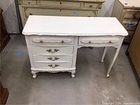 Front view showing five drawers, hardware, cabriole legs