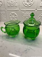 Front view of creamer and covered sugar bowl showing color and form