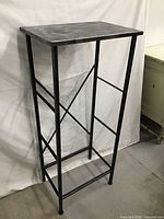 Full view of tall black metal console table with rectangular top
