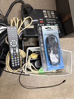 Lot overview showing remote, phone base, packaged Magellan cable and cords