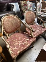 Pair of matching French-style accent chairs showing full frames, upholstery, and overall condition