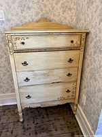 Front view of dresser showing four drawers, distressed finish, floral stencils, original pulls