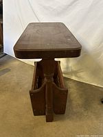 Side view showing full table, thick top, turned leg, magazine rack