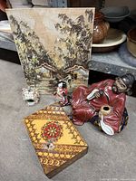 Group shot of all items: scholar figurine, geisha doll, shell incense burner, decorated wooden box, village painting