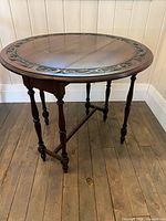 Full round table with leaves raised, showing turned legs and stretcher