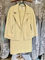Front view of jacket over dress on hanger