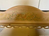 close-up of hand-painted floral decoration on top rail