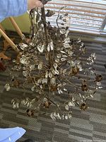 Full view of chandelier showing metal frame, crystals, chain
