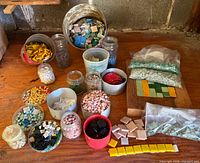 Overview of jars, bags and loose mosaic tiles on workbench