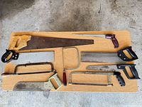 Saws and hacksaw frames laid out on tabletop