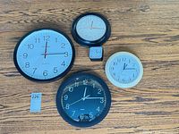 Group shot of five clocks on wooden floor