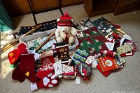 Overall lot showing stockings, plush bear, quilted mat, gift wrap supplies in tub