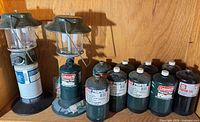 Shelf with two lanterns and eight propane cylinders