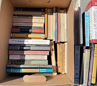 Box of horizontally stacked and vertically aligned books showing spines including Architecture of the Old South, Vasari, Frasier, Cat Owners Veterinary Handbook, Thailand, America
