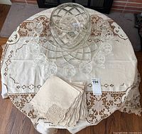 Top view of punch bowl, underplate, 11 cups, tablecloth and napkins