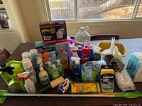Full lot overview of cleaning products, tools, paper goods on table